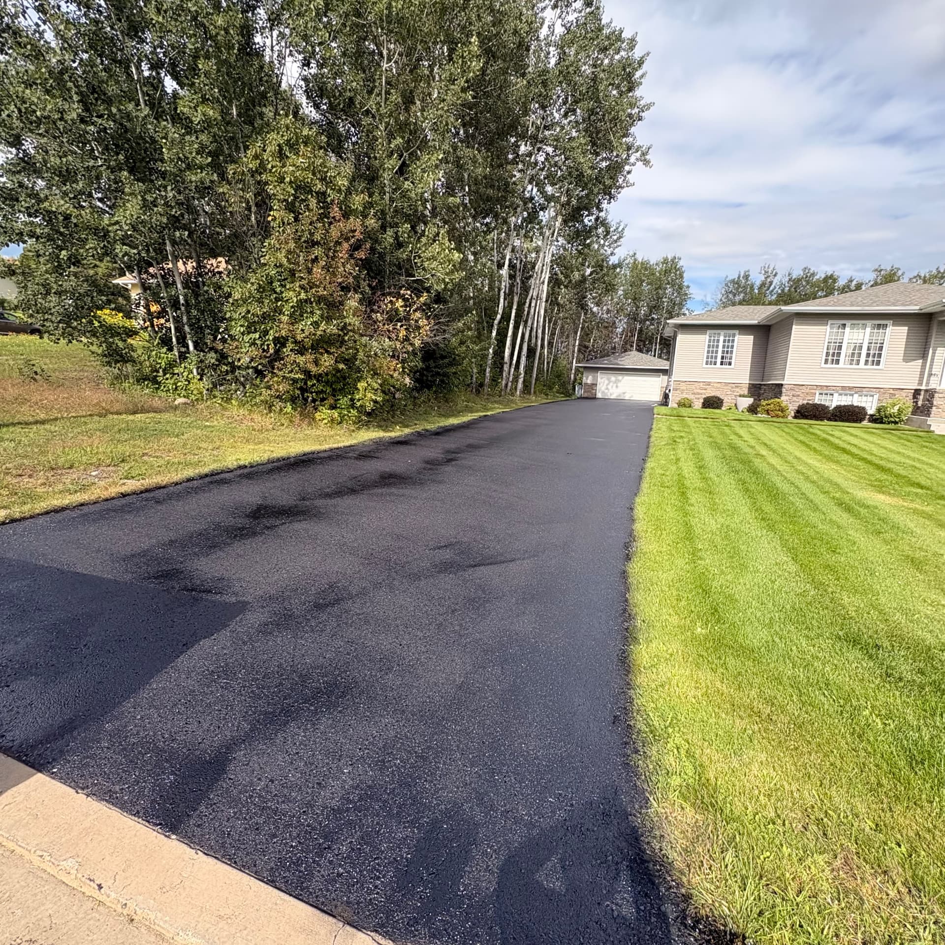 Freshly restored and sealed black asphalt driveway