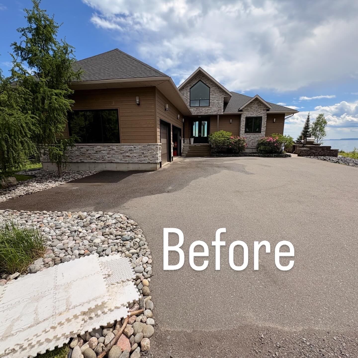 Weathered asphalt driveway before sealing at a lakeside home