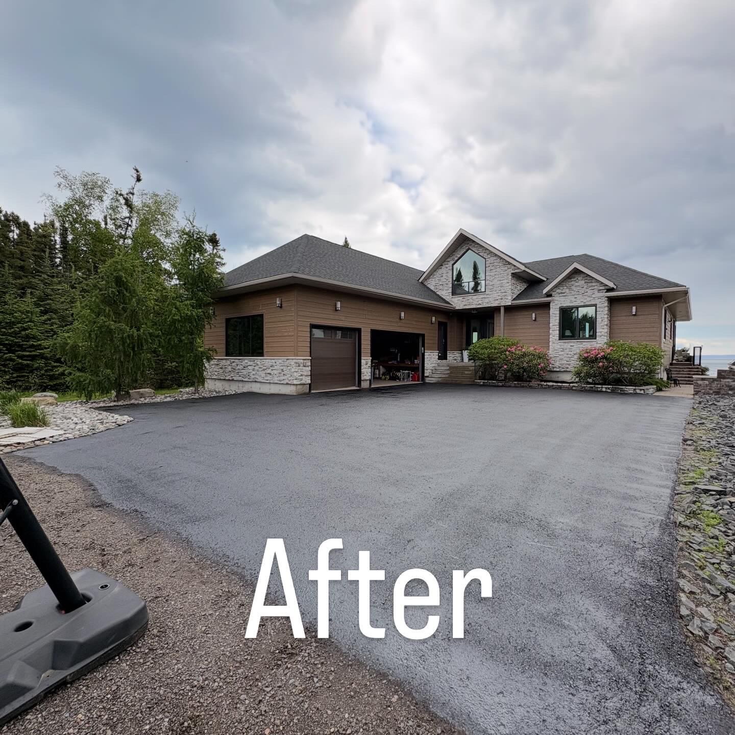 Freshly sealed black asphalt driveway at a lakeside home in Thunder Bay
